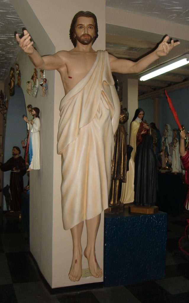 a life-sized sculpture of a resurrected figure with outstretched arms