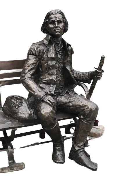 Bronze sculpture of a seated historical figure on a bench