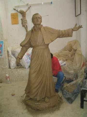 clay sculpture of a figure with outstretched arms
