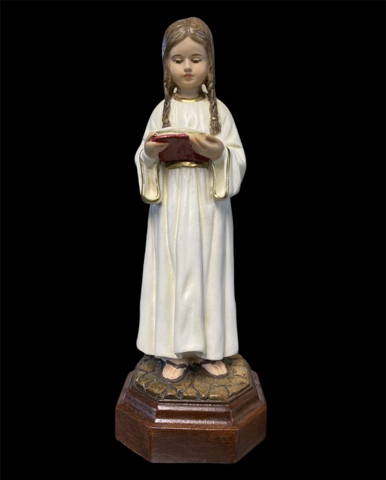 figurine of a young girl in a white dress holding a book