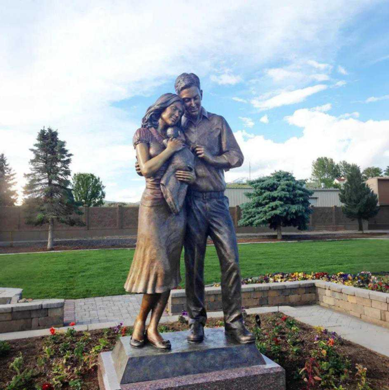 bronze sculpture of a couple holding a child outdoors