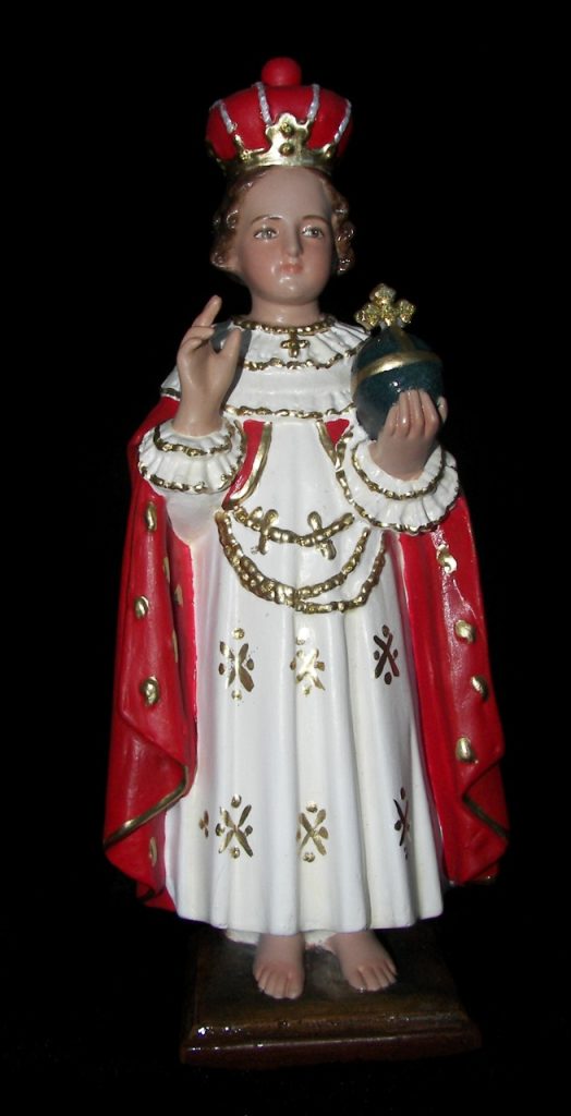 figurine of a crowned figure holding a globe and gesturing