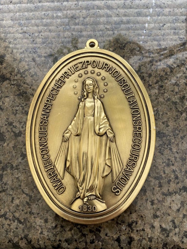 bronze medallion depicting a figure in religious attire