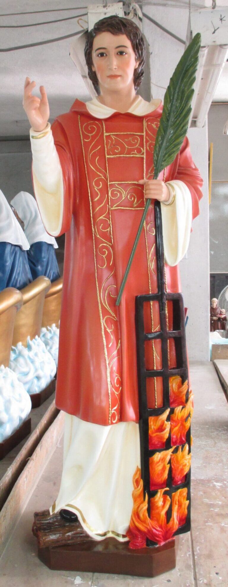 a standing figure in red robes holding a palm and a torch