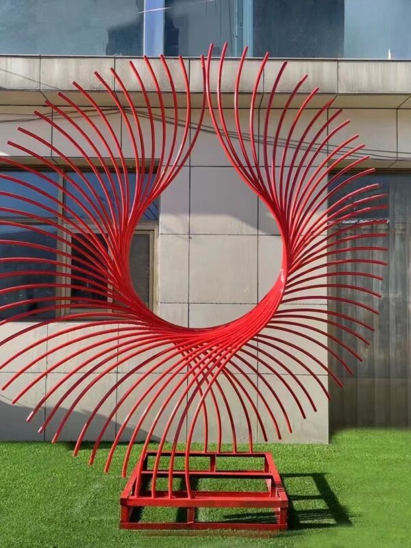 Red abstract sculpture with spiraling metal lines